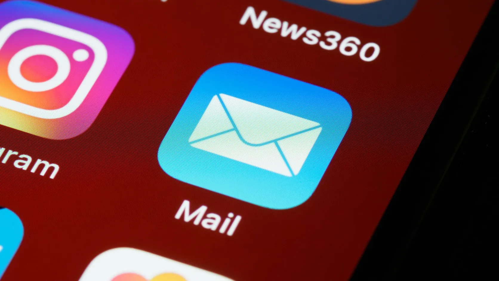 Gros plan sur l'icône de l'application Mail sur l'écran d'un smartphone, à côté de l'icône Instagram